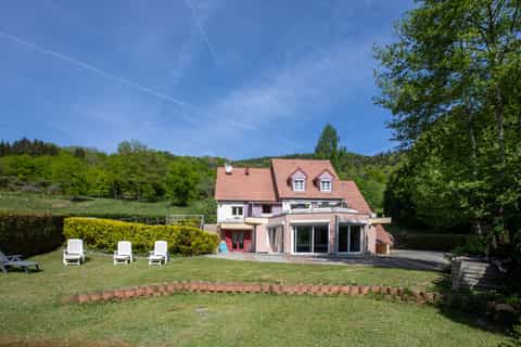 Façade arrière du gîte Gentiane vue du jardin avec verrière panoramique et transats (gîte groupe 15 personnes, vallée de la Thur, Alsace)