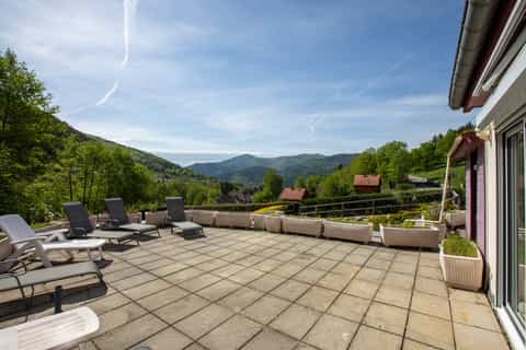 Grande terrasse panoramique du gîte Gentiane avec transats et vue sur les Hautes-Vosges (gîte 15 personnes à Saint-Amarin, Alsace)