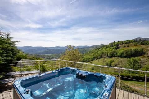 Spa extérieur privatif du gîte Jonquille avec vue panoramique sur les crêtes vosgiennes