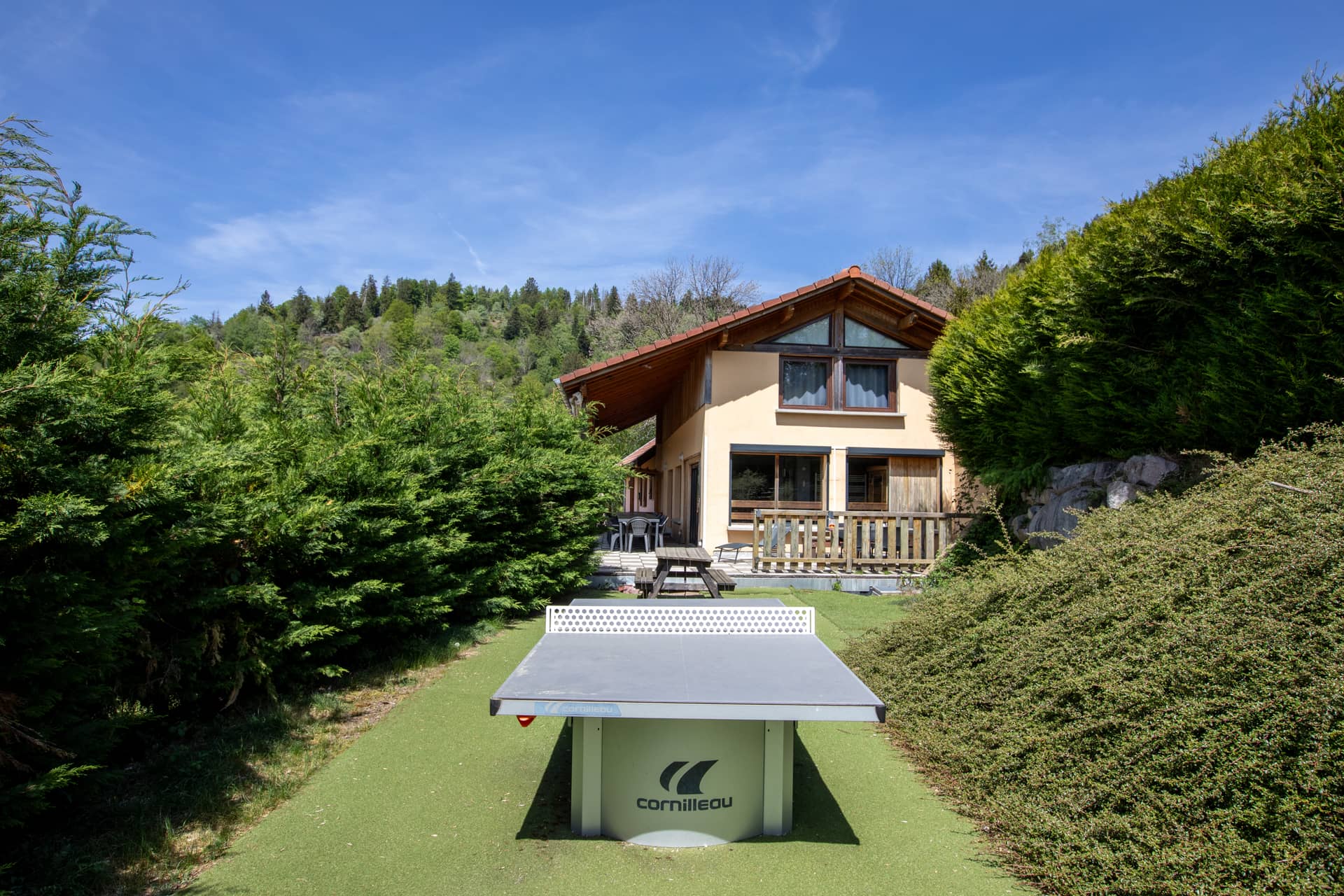 Façade arrière du gîte Jonquille avec table de ping-pong dans le jardin