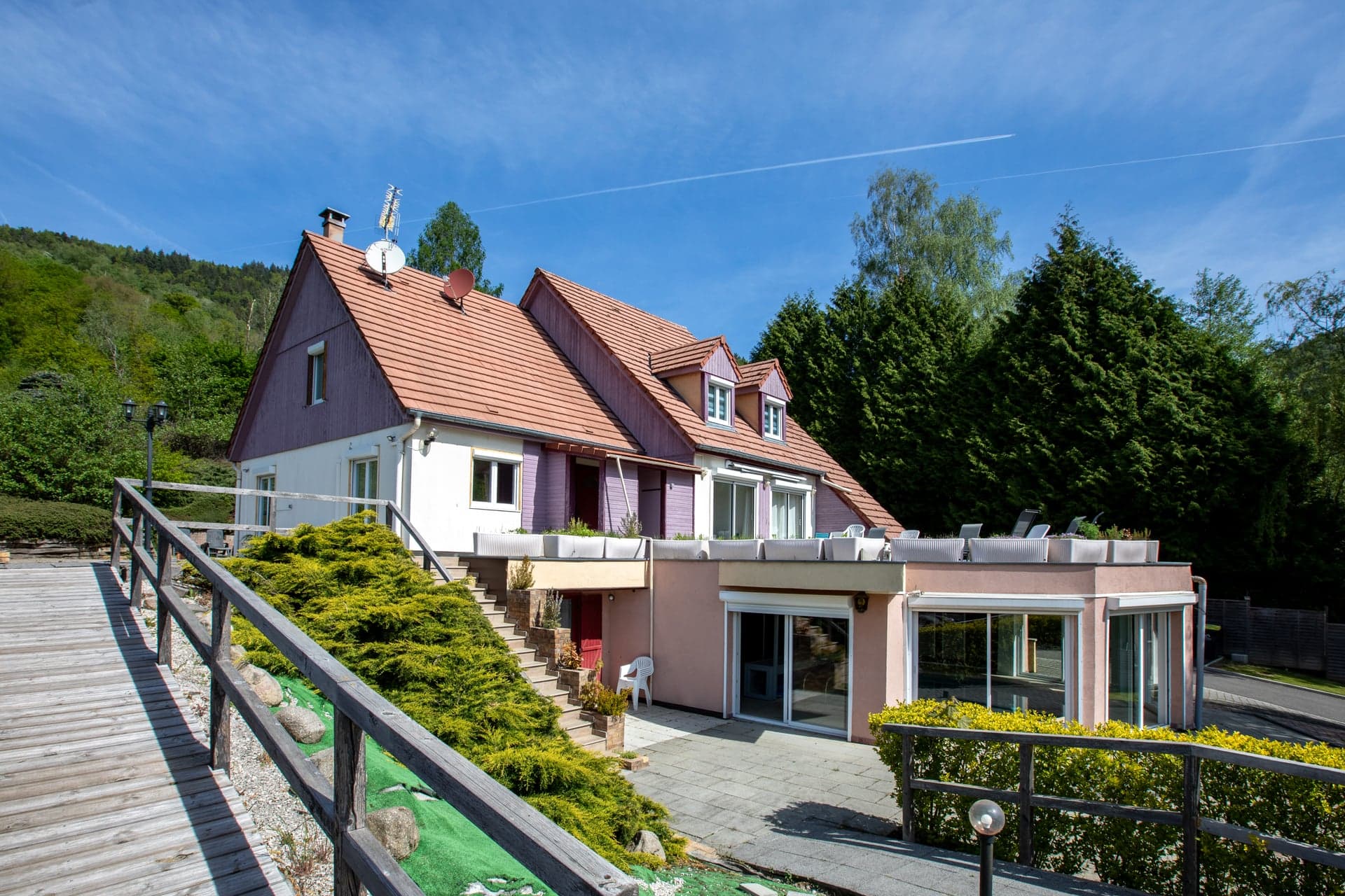 Façade nord-est du gîte Gentiane à Saint-Amarin avec terrasse couverte ronde et passerelle d'accès (gîte 15 personnes, Hautes-Vosges, Alsace)