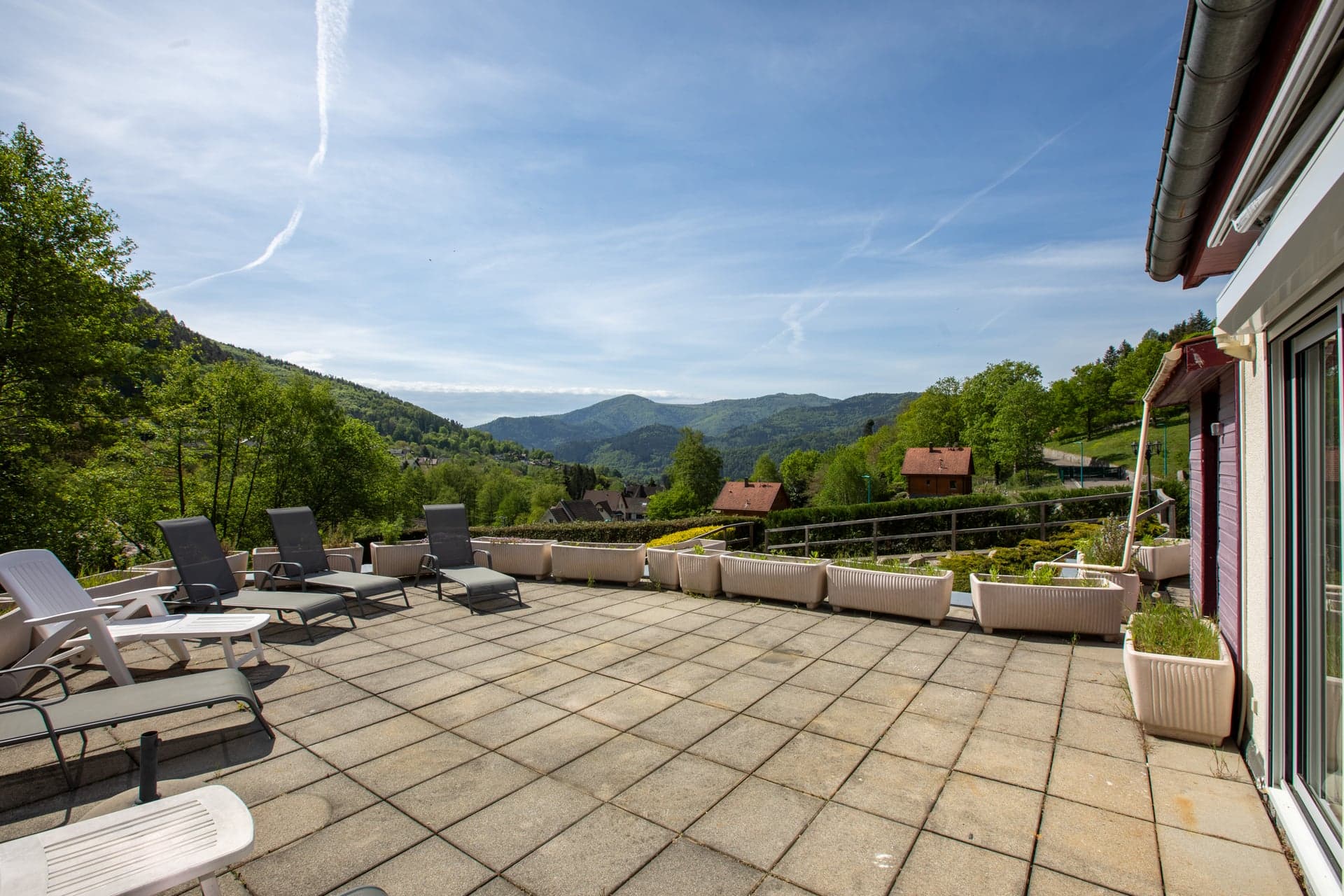 Grande terrasse panoramique du gîte Gentiane avec transats et vue sur les Hautes-Vosges (gîte 15 personnes à Saint-Amarin, Alsace)