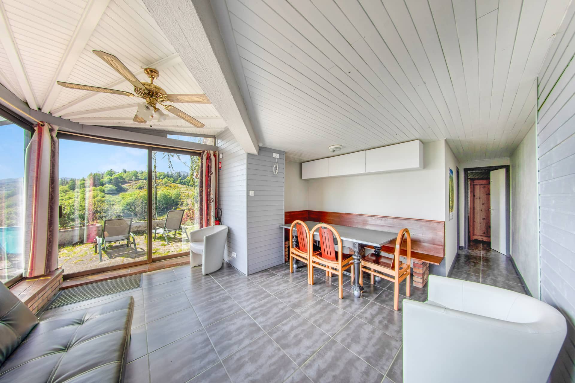 Salon et salle à manger de l'annexe Violette avec vue terrasse sur la vallée vosgienne