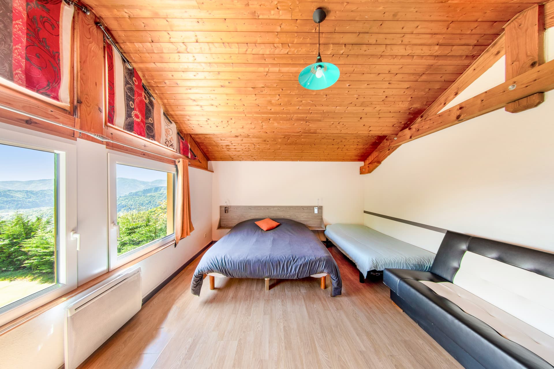 Chambre vue vallée du gîte Jonquille, plafond bois et grande fenêtre panoramique sur les Vosges