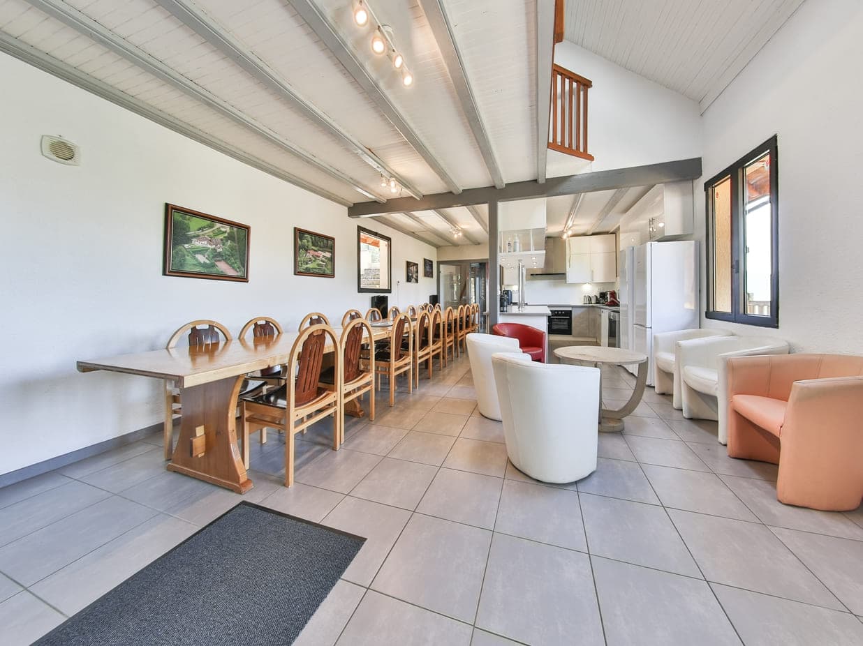 Grande salle à manger du Domaine du Gomm avec cuisine ouverte pour 24 convives